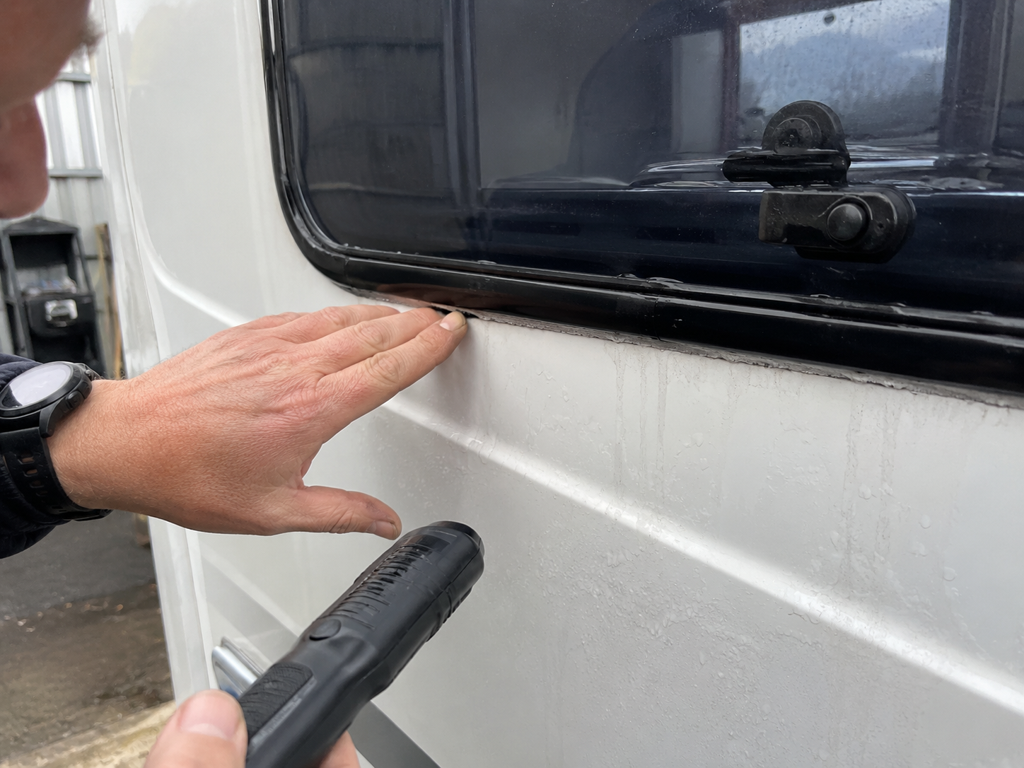 Close-up inspection of caravan window seal and water leak area