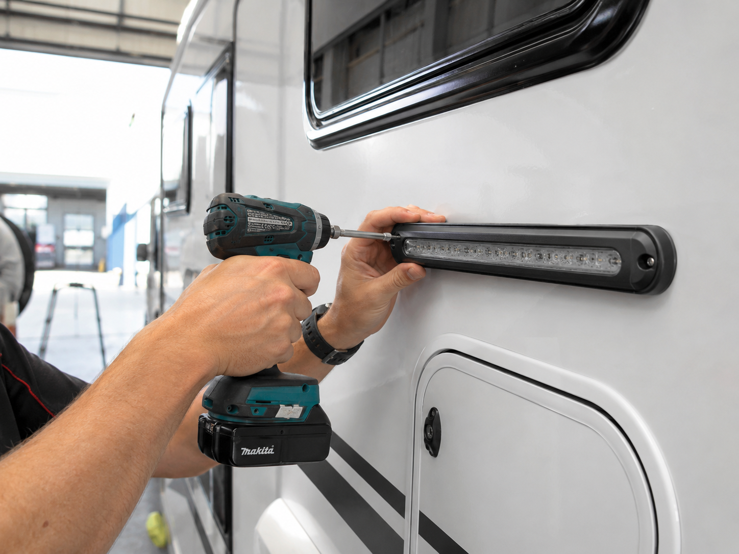 Technician installing caravan accessory at Central Coast workshop